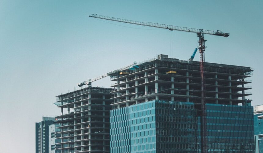 Skyline view of modern skyscrapers under construction with cranes