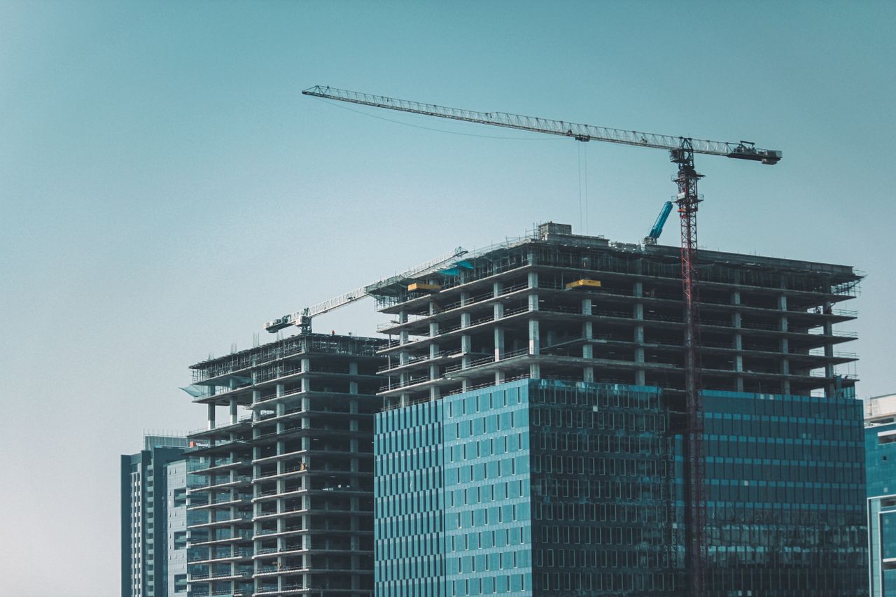 Skyline view of modern skyscrapers under construction with cranes