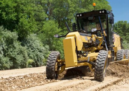 Yellow motor grader operating at a construction site