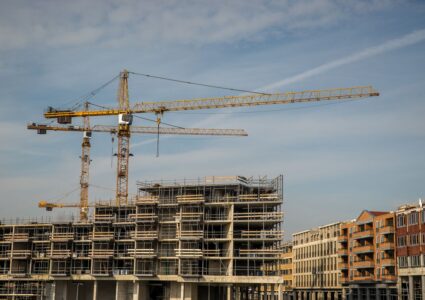 construction site with cranes and partially built structures under a clear sky.