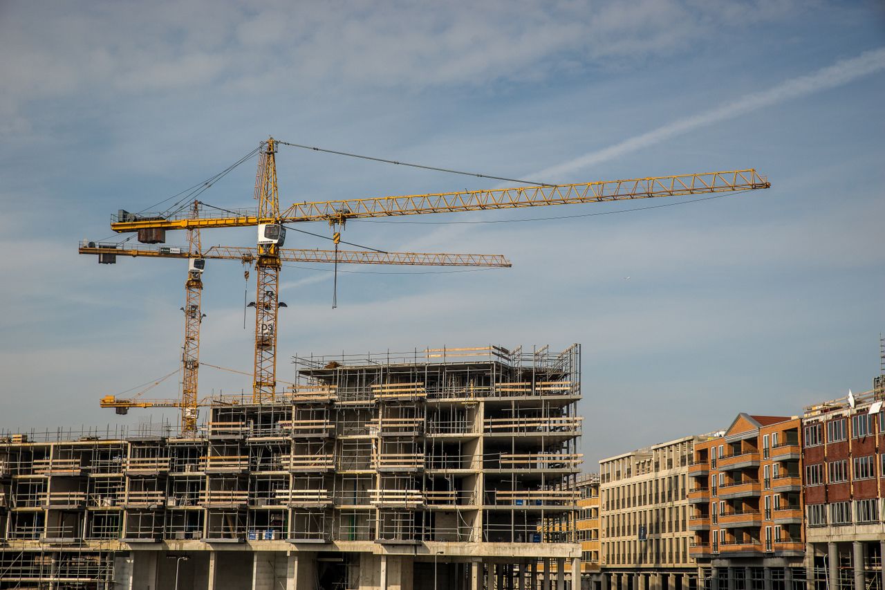 construction site with cranes and partially built structures under a clear sky.