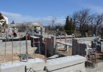 Sunlit construction site with workers on concrete foundation