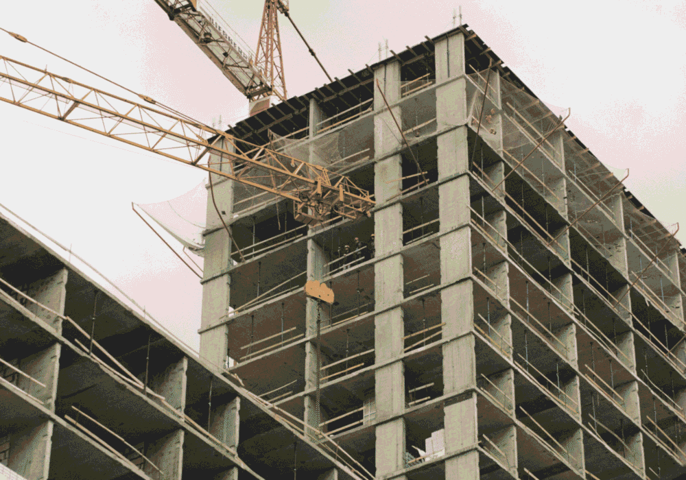 towering construction site featuring a crane and concrete structure during its development phase