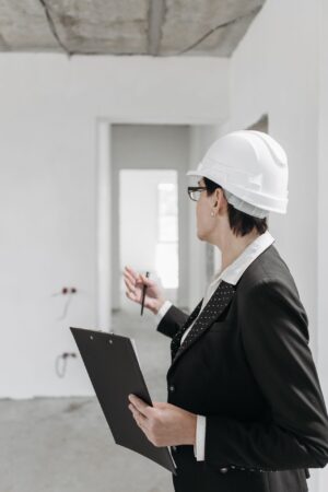 professional engineer in a suit and hard hat inspecting a construction site with a clipboard